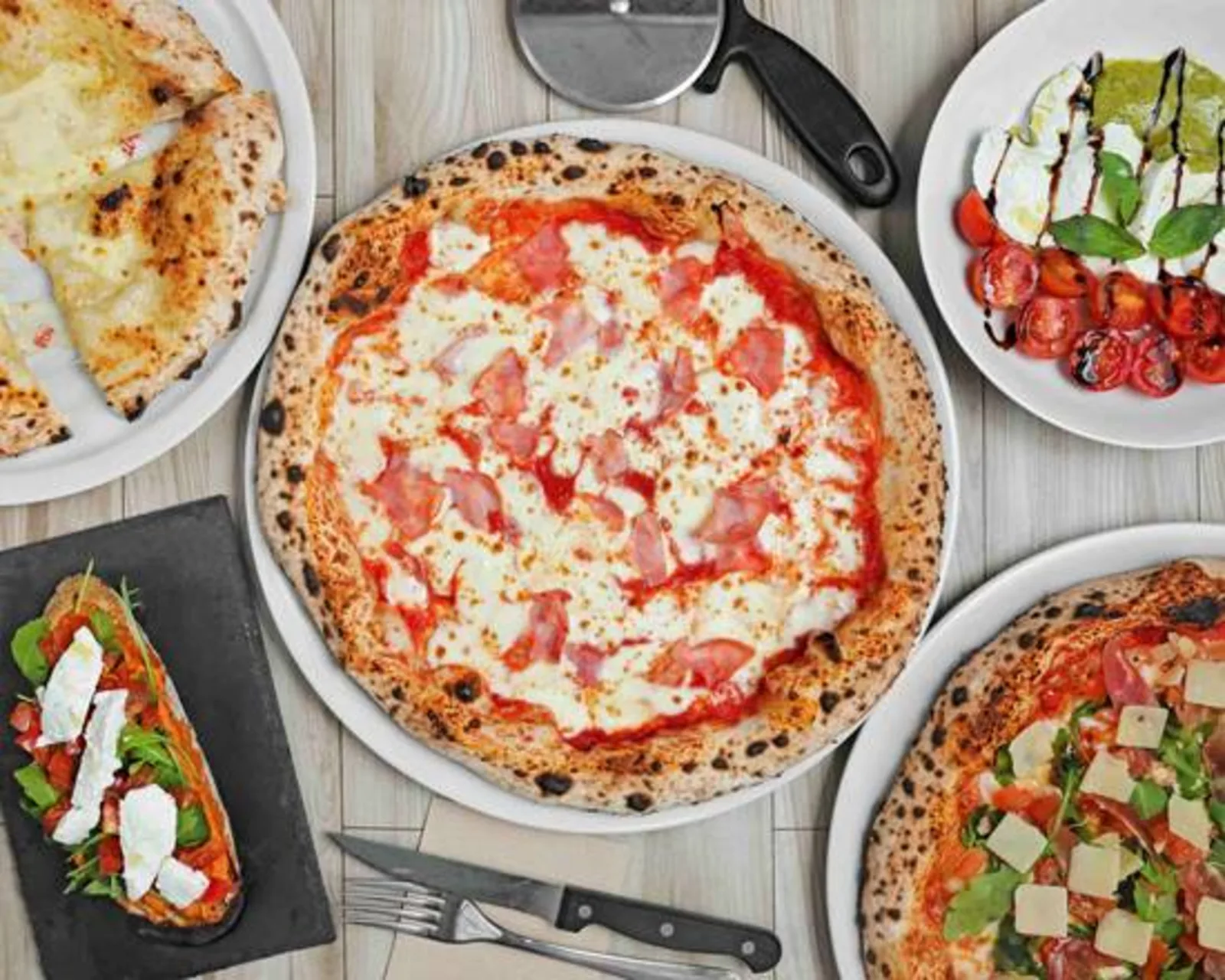 Varias pizzas napolitanas servidas en la mesa del local de Hortaleza